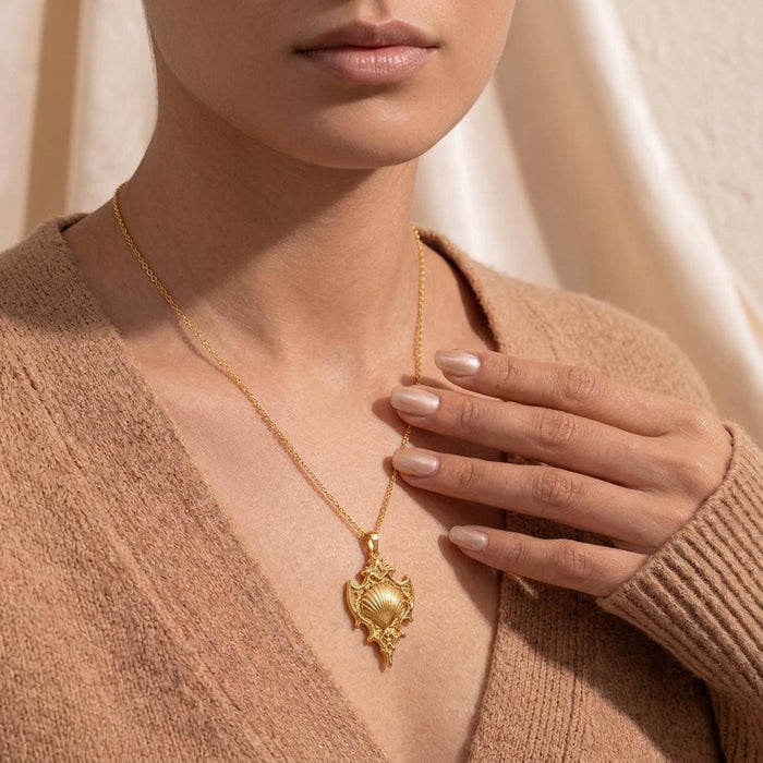 Close view of the Sacred Shell Relic pendant necklace worn with a neutral knit top