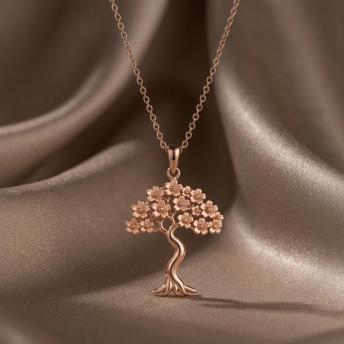 Rose-tone Sakura Bloom tree pendant suspended over brown satin