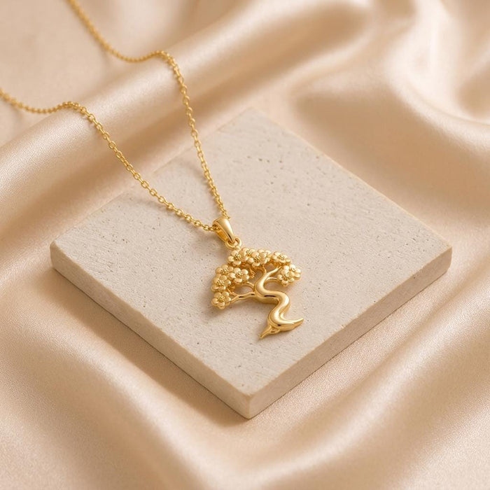 Gold Plated Silver Sakura Cloud Bonsai pendant displayed on a square stone block over satin