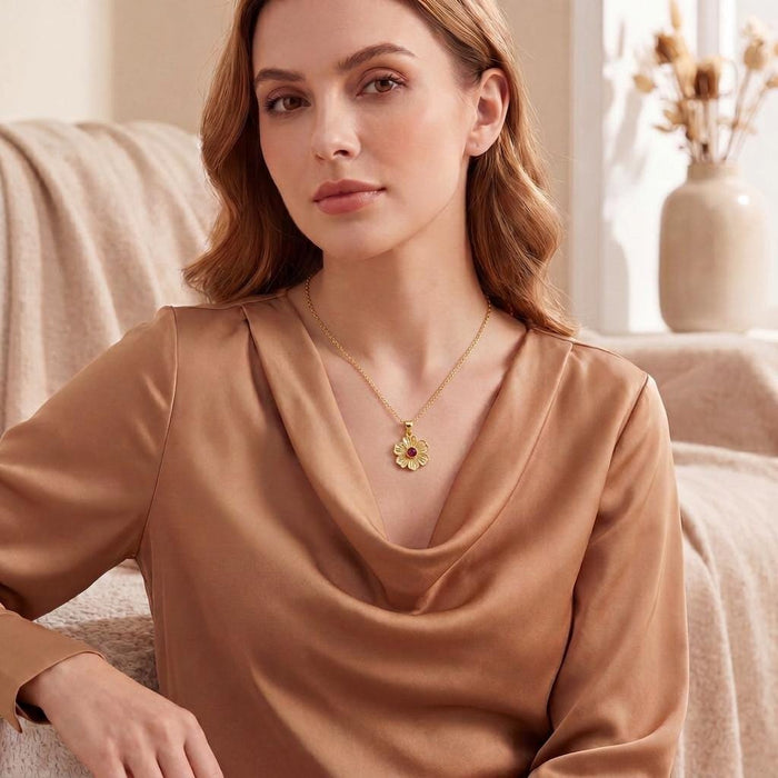 Model wearing a Gold Plated Silver Stock Flower Necklace with a red round center stone and satin cowl-neck blouse