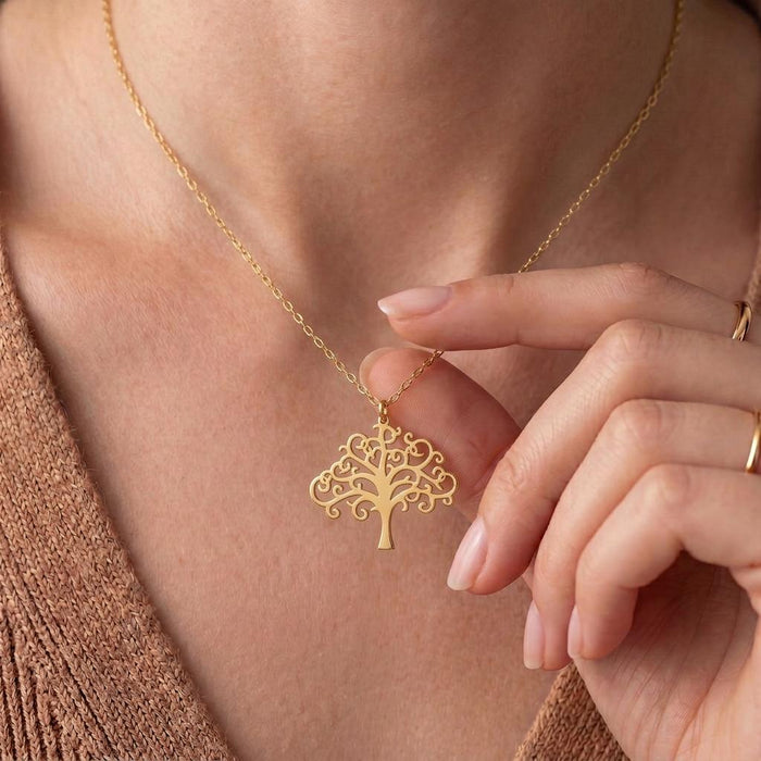 Gold Plated Silver scrollwork Tree of Life necklace held at the chest