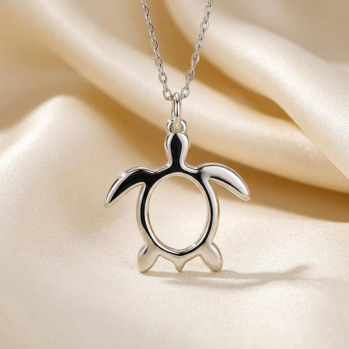 Front view of a polished sea turtle pendant with a rounded open center