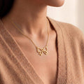 Gold Plated Silver Bow Pendant Necklace worn at the neckline with a beige V-neck knit top