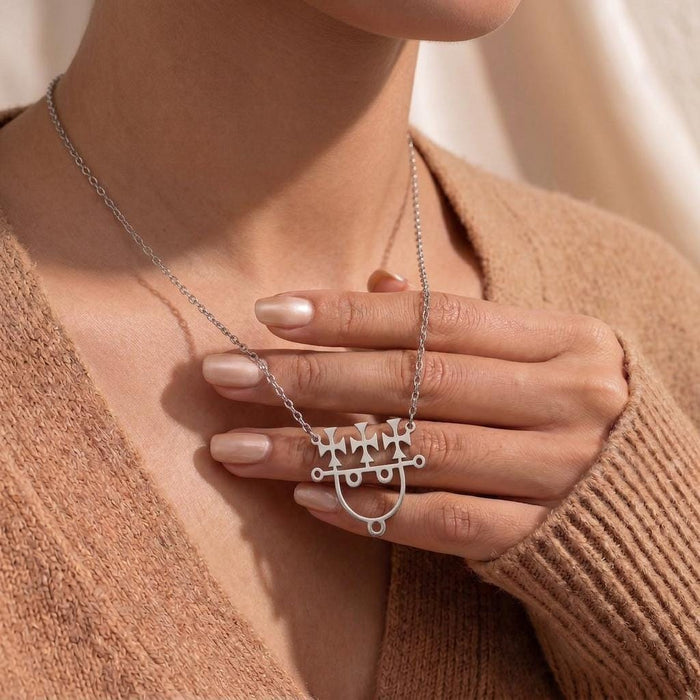 Model holding the silver Sitri Seal Sigil Necklace against a knit cardigan