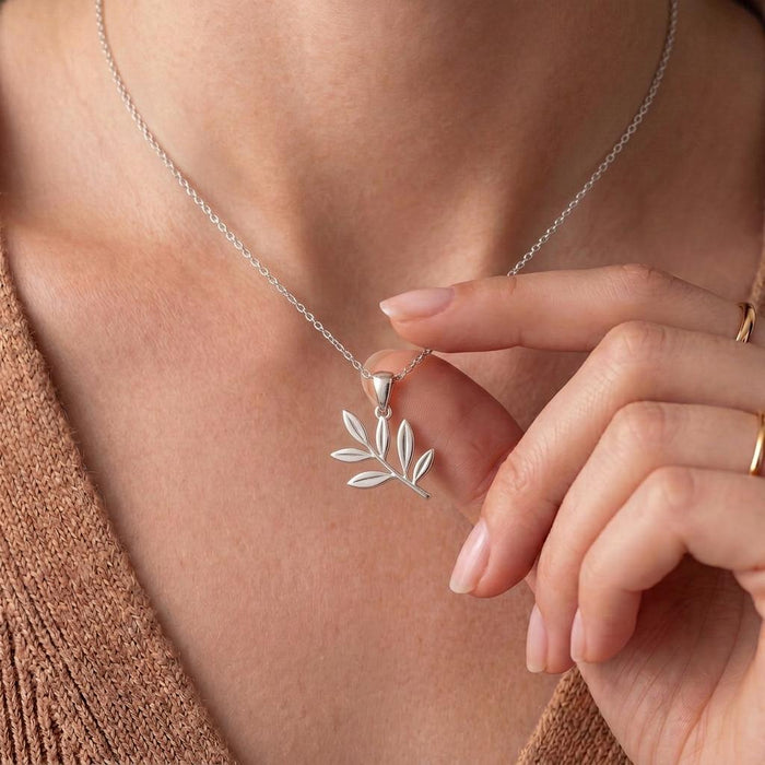 Close-up of the Olive Branch Necklace pendant held at the neckline