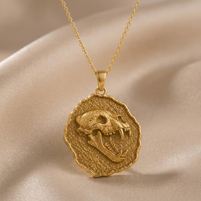 Gold Plated Silver Cave Bear Fossil Pendant Necklace with raised skull relief on beige satin