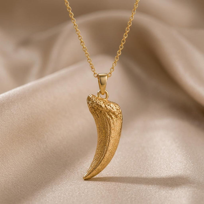 Gold Plated Silver Smilodon fang fossil pendant necklace with a textured curved fang on champagne satin