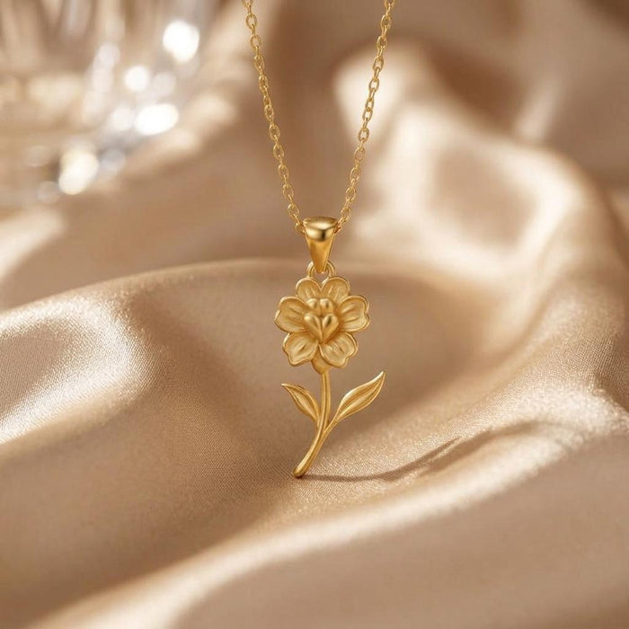 Front view of a Gold Plated Silver layered flower pendant with a curved stem and two pointed leaves on champagne satin