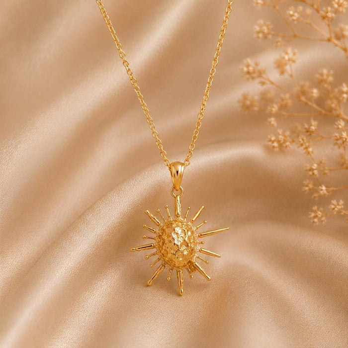 Solar Fragment Necklace in Gold Plated Silver with a textured circular center and irregular rays on champagne satin
