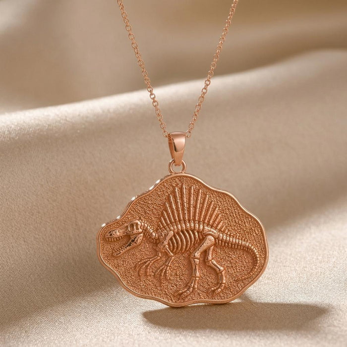 Rose Gold Plated Spinosaurus Fossil Pendant Necklace close-up on draped satin