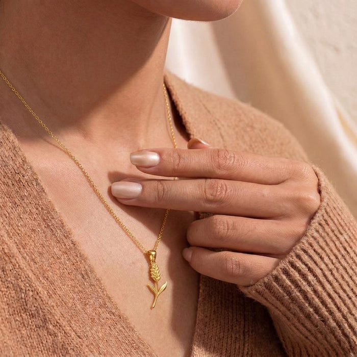 Model holding a Gold Plated Silver Statice Flower Pendant Necklace at the neckline