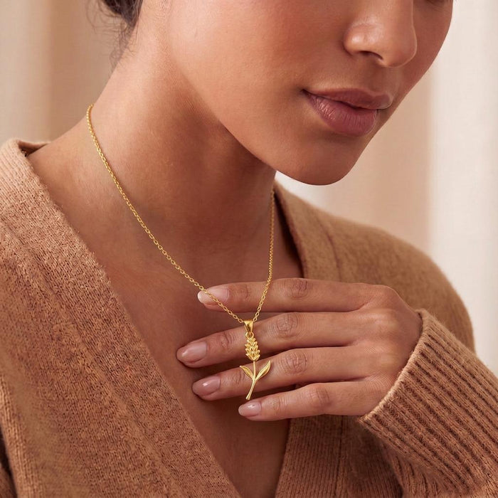 Close portrait of a model holding a Gold Plated Silver Statice Flower Pendant Necklace