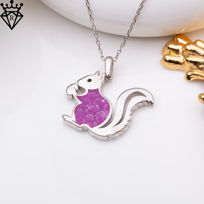 Amethyst squirrel necklace displayed on a white surface beside gold decorative objects