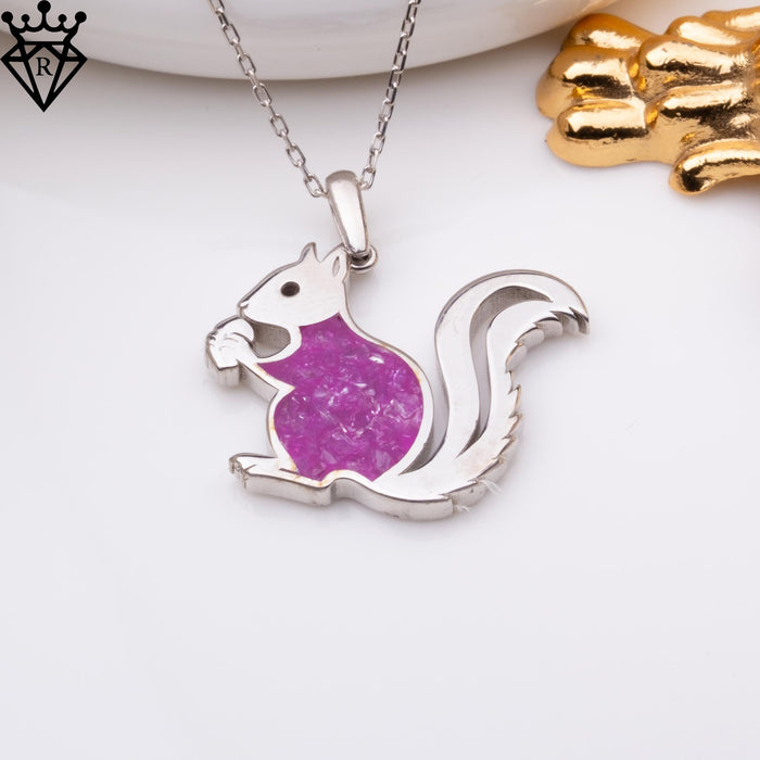 Close-up amethyst squirrel pendant photograph beside gold decorative objects