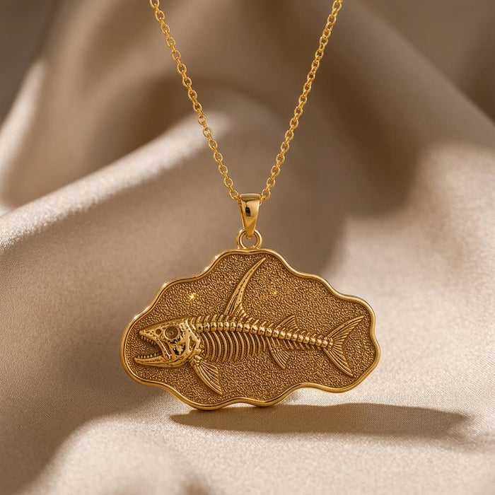 Close-up of a Gold Plated Silver Stethacanthus fish skeleton pendant over beige satin