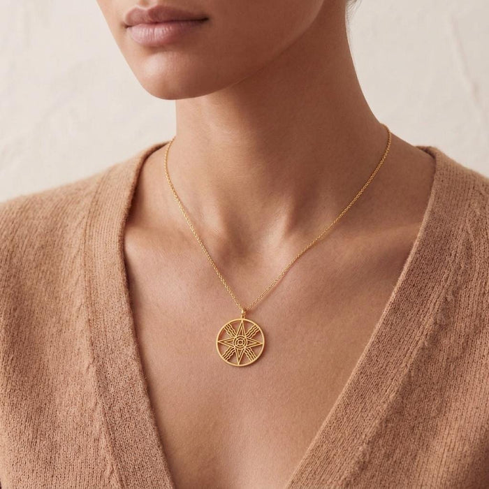 Gold Plated Silver Sumerian Sun Pendant Necklace worn over a beige V-neck knit top