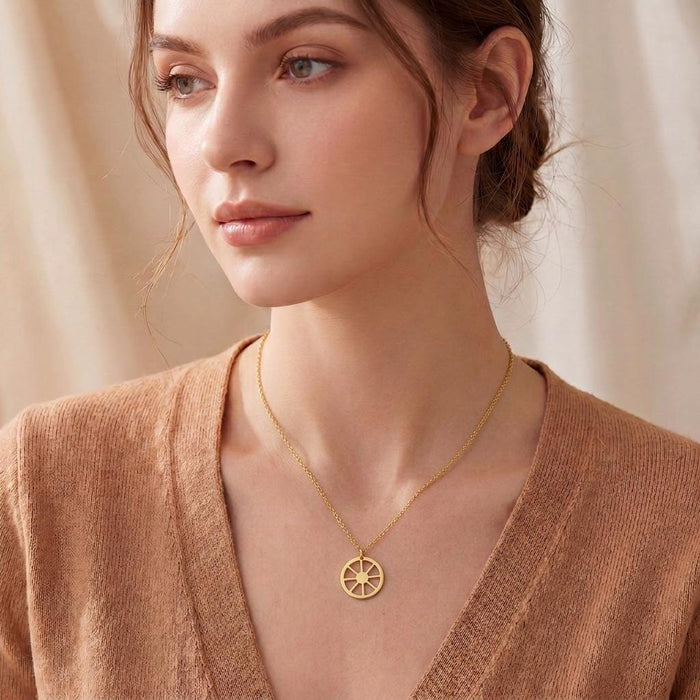 Gold Plated Silver Sun Symbol Necklace with a round eight-spoke wheel pendant worn at the neckline