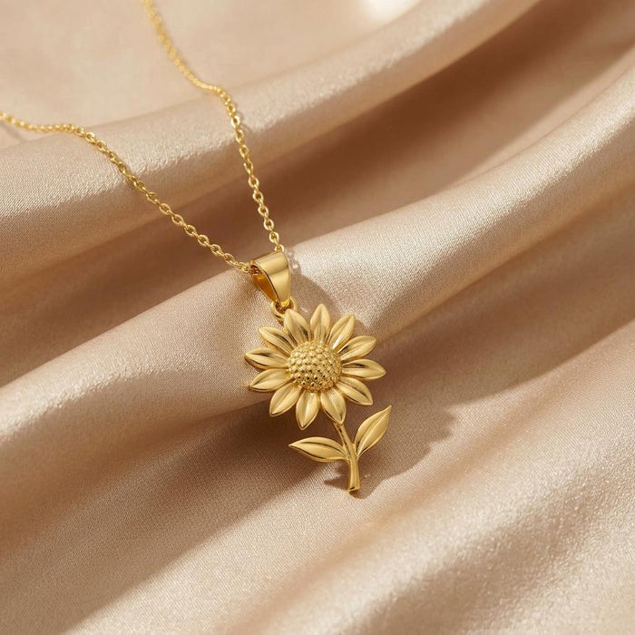 Gold Plated Silver Sunflower Pendant Necklace with sculpted petals and a textured center on champagne satin