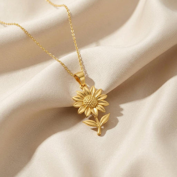 Gold Plated Silver Sunflower Pendant Necklace with curved stem displayed on ivory satin
