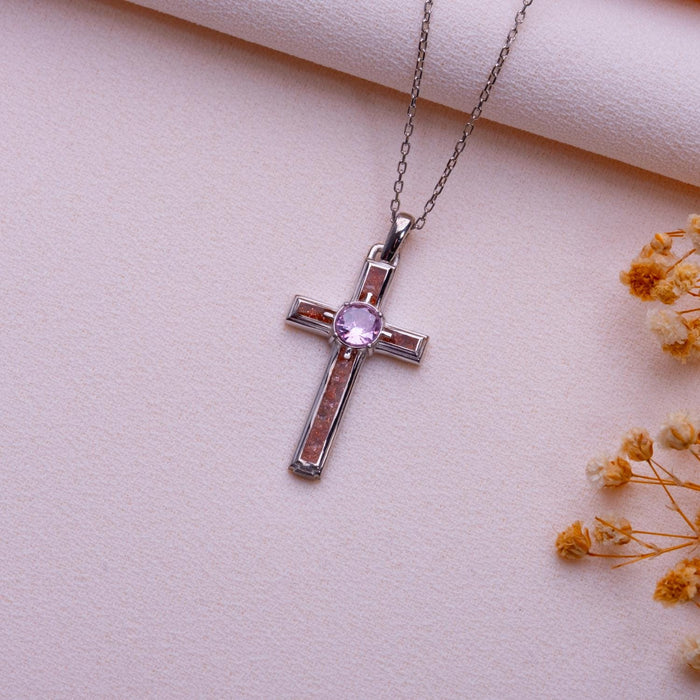 Angled view of the Sunstone Cross Necklace with framed inlay arms and round center stone