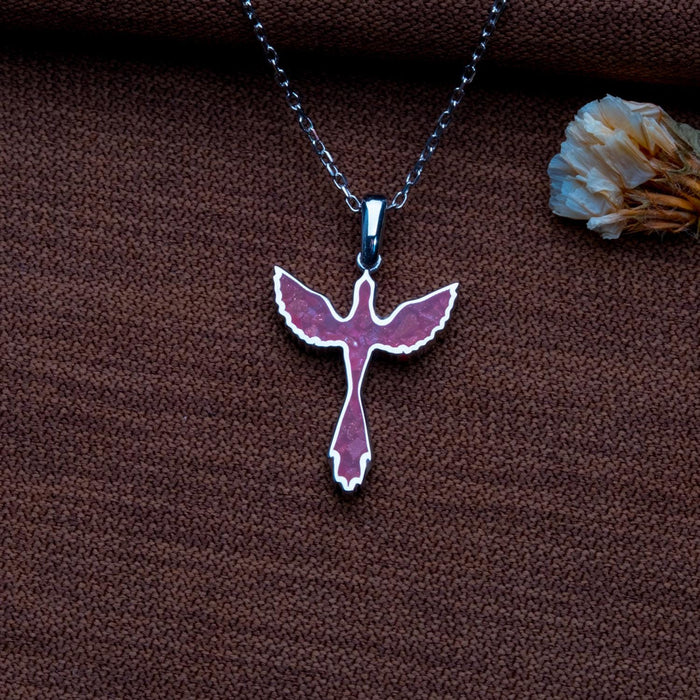 Sunstone jasper dove necklace on dark textured fabric beside a dried flower