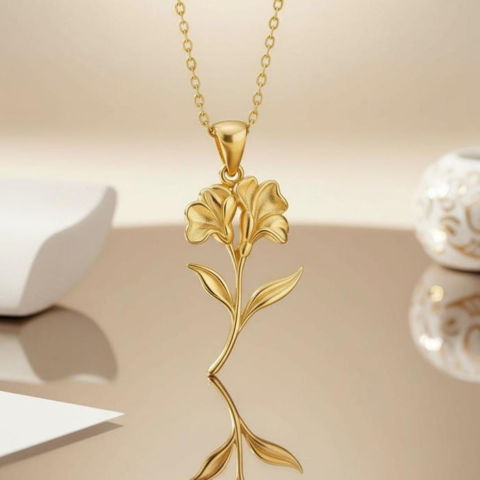 Gold Plated Silver sweet pea pendant with layered blooms and curved stem on a reflective surface