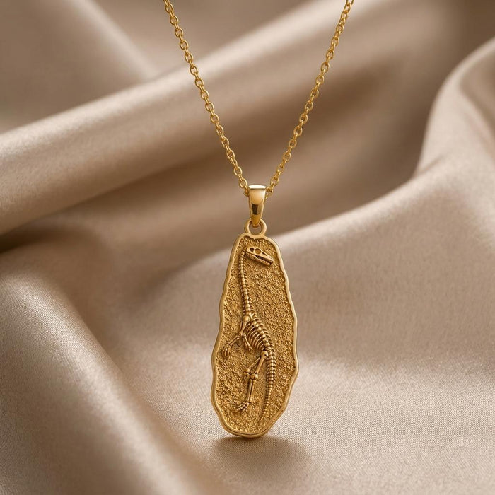 Gold Plated Silver Tanystropheus fossil pendant necklace with raised skeleton relief on champagne satin