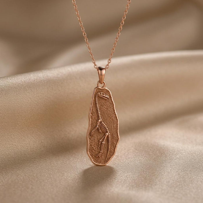 Rose Gold Plated Tanystropheus fossil pendant necklace with textured fossil plaque on champagne satin