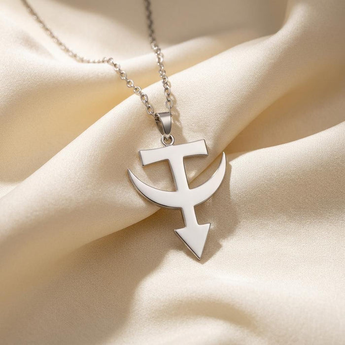 Close-up of the polished Tataria symbol pendant on ivory satin