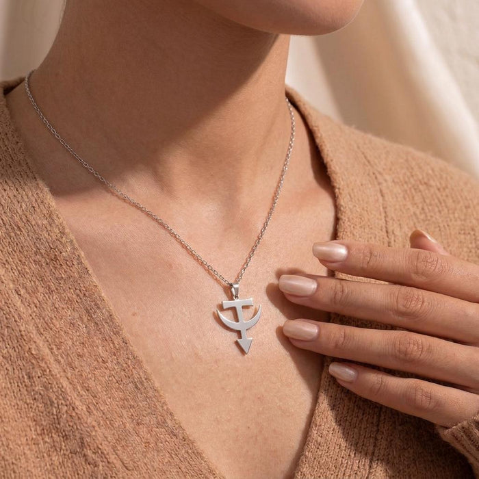 Close-up of the Tataria Symbol Necklace worn with a hand near the pendant