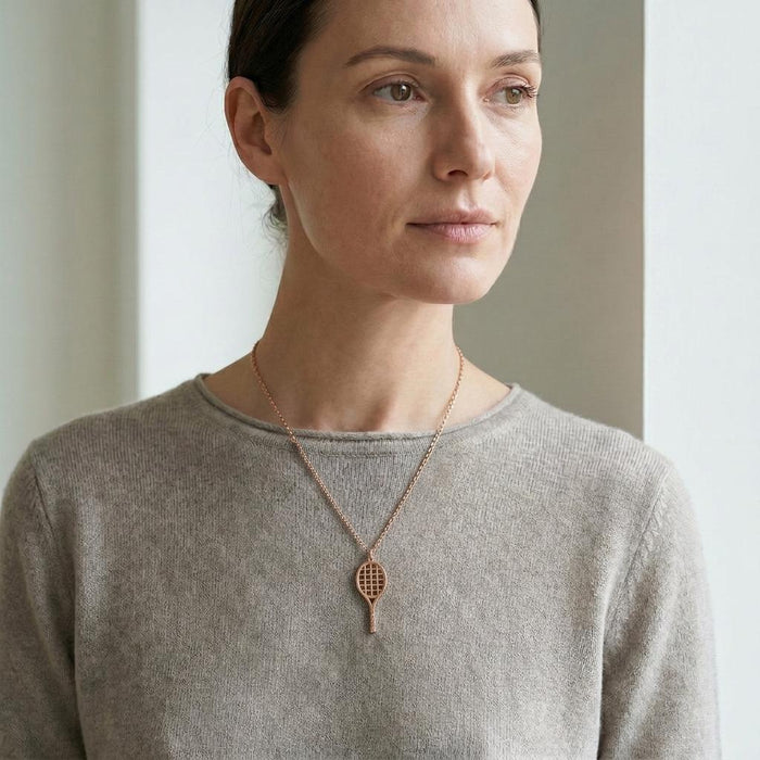 Rose Gold Plated Tennis Racket Necklace worn over a light gray sweater