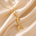 Gold Plated Silver Mermaid Tail Silhouette Necklace on champagne satin, showing the flowing hair detail, textured tail, and split fin