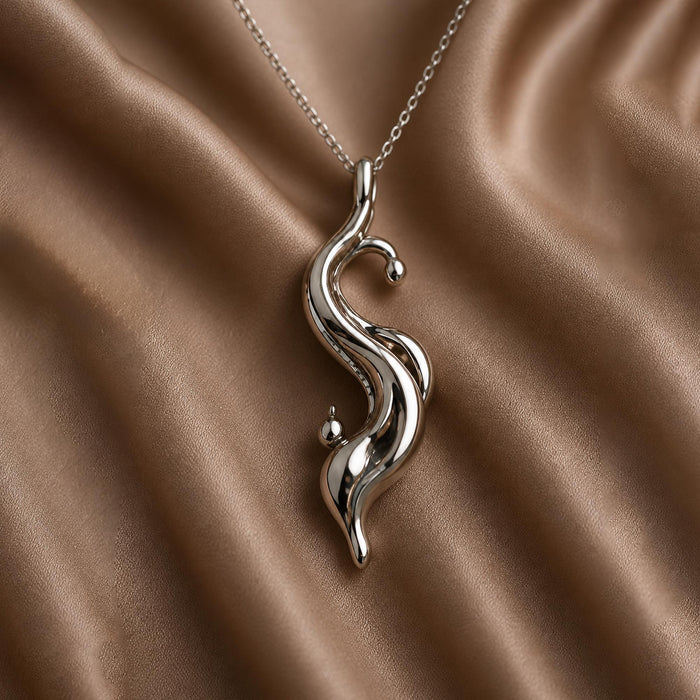 Silver Tidal Drop Pendant Necklace with intertwined flowing curves on brown satin