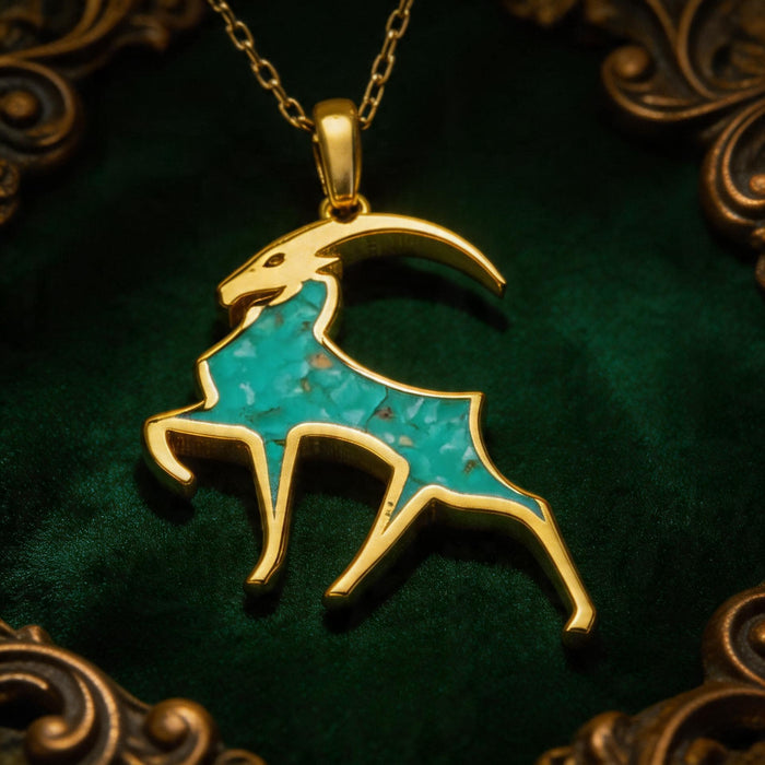 Gold Plated Silver Capricorn goat necklace arranged on green velvet