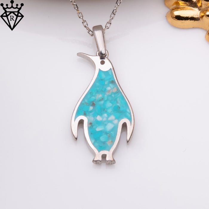 Front view of a turquoise-inlay penguin pendant suspended from a silver chain