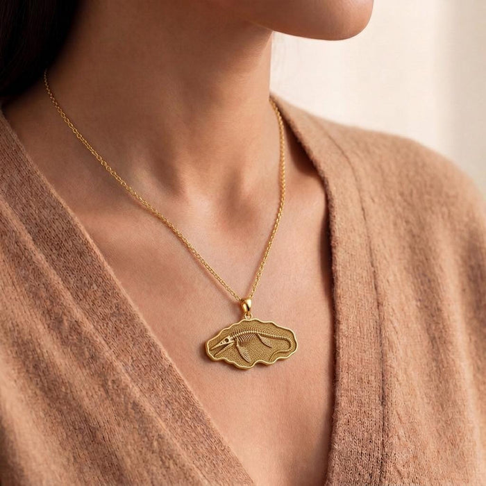 Gold Plated Silver Tylosaurus fossil pendant necklace worn at the neckline with a knit top