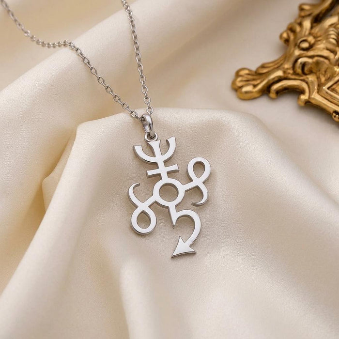 Close-up of the silver Typhon Symbol Necklace with circular center and curved loops on ivory satin