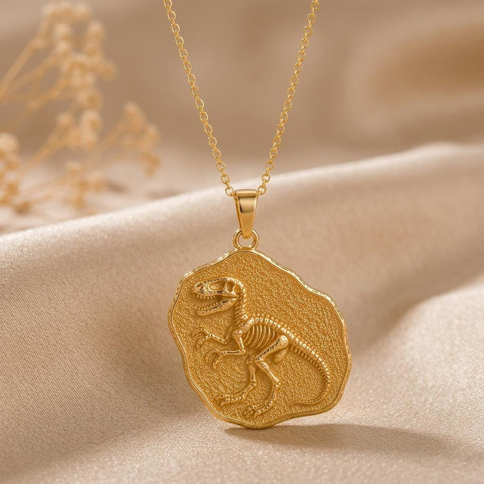 Gold-finish Velociraptor Fossil Pendant with a raised skeleton motif on a textured irregular medallion over champagne satin