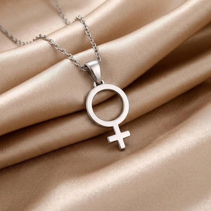 Polished Venus symbol pendant displayed on champagne satin