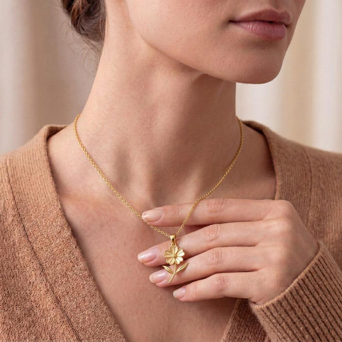 Gold Plated Silver Verbena Flower Pendant Necklace worn with the floral pendant held between the fingers