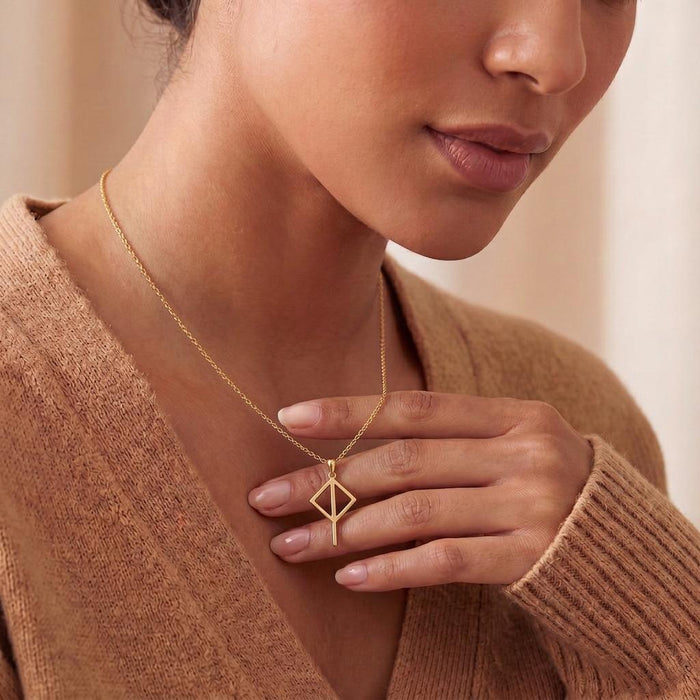 Gold Plated Silver Viking Balance Rune Necklace worn at the collarbone with a hand near the pendant