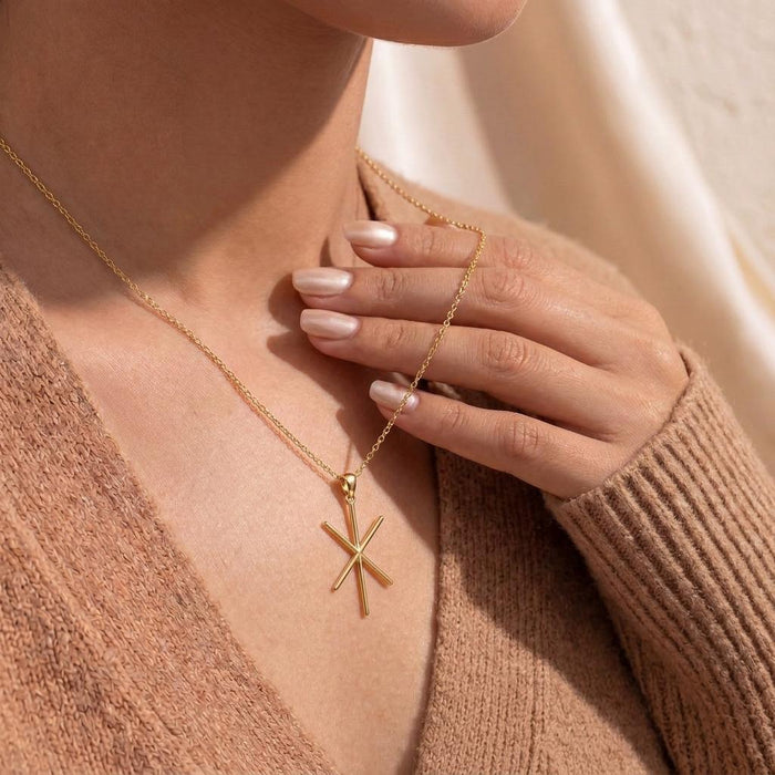 Gold Plated Silver Viking Strength Bind Rune Necklace worn with a textured neutral cardigan