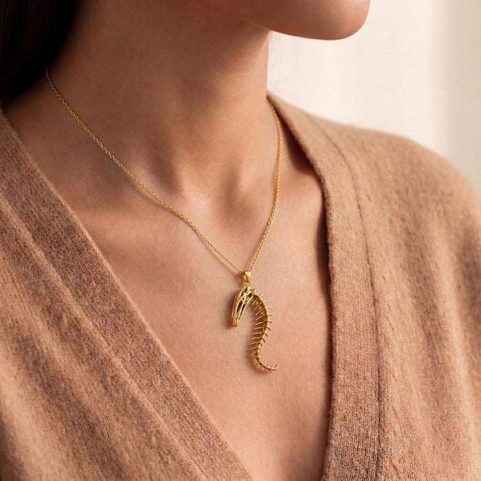 Gold Plated Silver Whale Spine Relic necklace worn at the collarbone with a neutral knit top