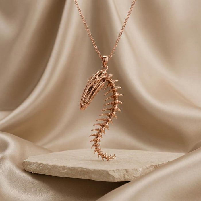 Rose Gold Plated Whale Spine Relic pendant necklace displayed above a pale stone slab and draped fabric